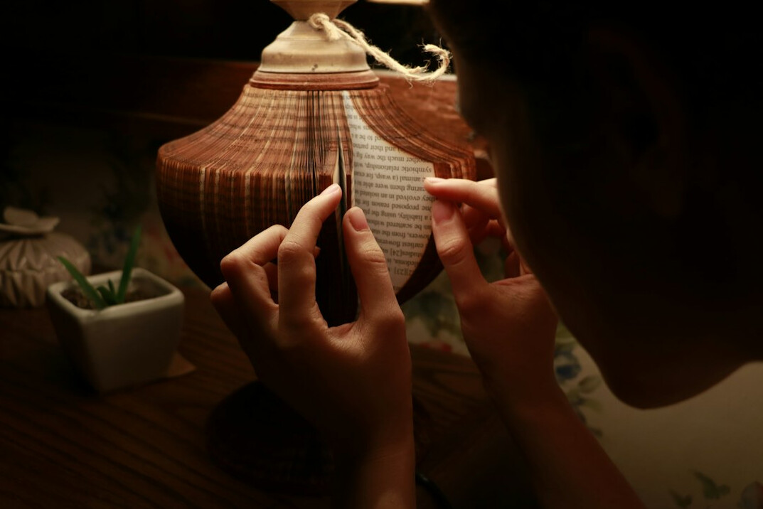 Uruguayan editor writing notes at a desk with a lamp, side view