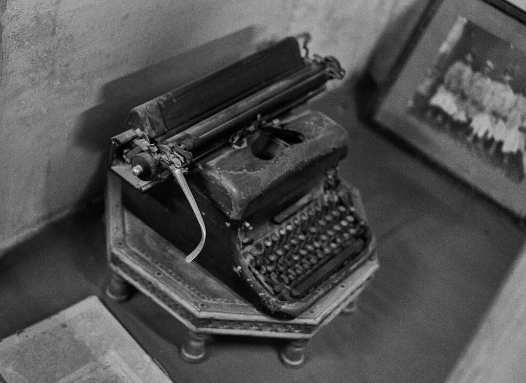 Vintage typewriter with scattered papers and a cup of coffee on a desk