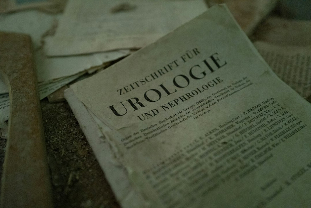 Stack of old documents, folders and a magnifying glass on a desk